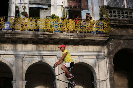 Felix Guirola, 52, rides a homemade bike with an advertising banner in Havana, Cuba, July 20, 2016. REUTERS/Alexandre Meneghini