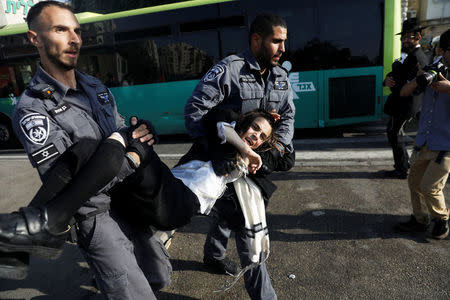 Israeli policemen carry an ultra-Orthodox Jewish youth during clashes at a protest against the detention of an ultra-Orthodox man who refuses to serve in the Israeli army, in Jerusalem September 17, 2017 REUTERS/Ronen Zvulun