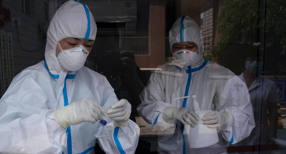 Pictured are medical workers checking test samples at Beijing Puren hospital.