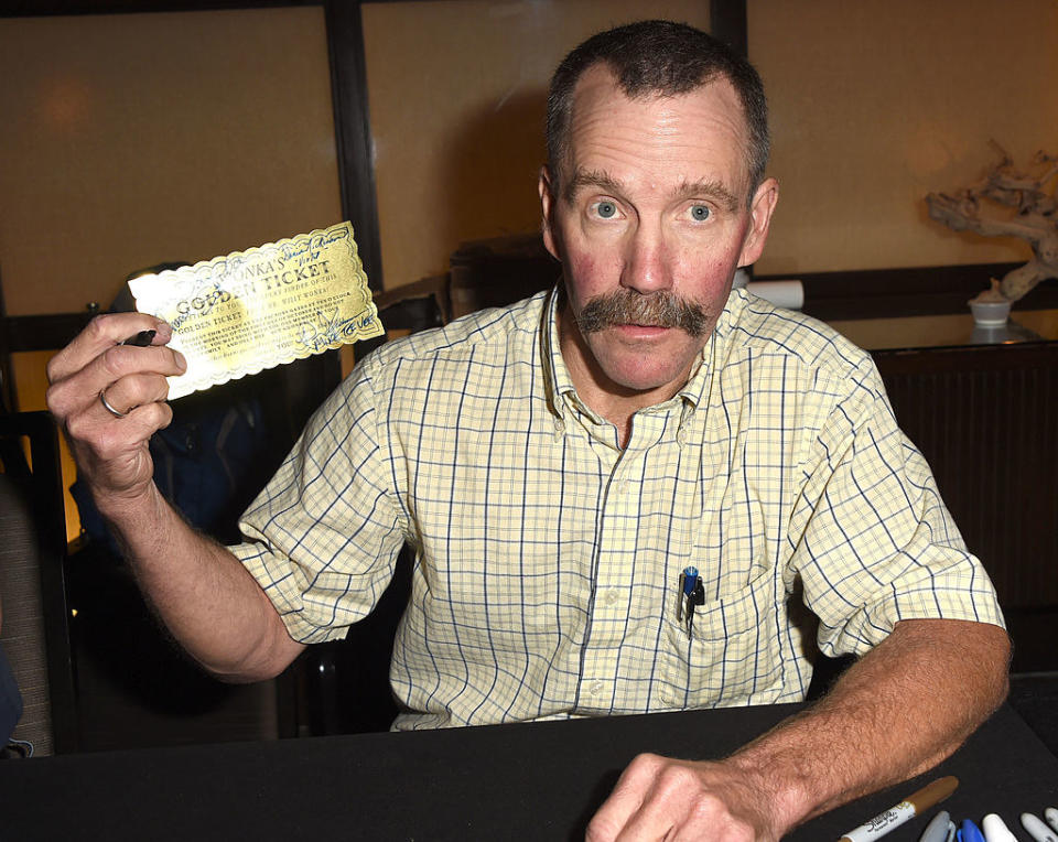 Peter as an adult holding a Wonka's Golden Ticket