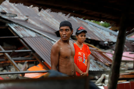 A couple collects valuable goods for a new temporary shelter at the epicentre of a devastating earthquake at Lende Tovea village in Donggala, Sulawesi island, Indonesia October 6, 2018. REUTERS/Beawiharta