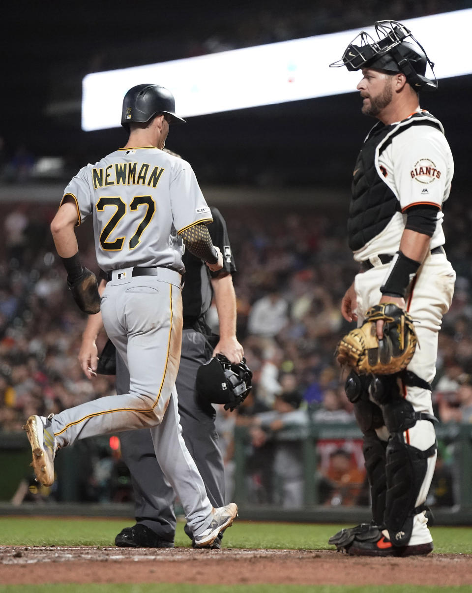 Pittsburgh Pirates' Kevin Newman (27) scores a run past San Francisco Giants catcher Stephen Vogt, right, on a single by Colin Moran during the fifth inning of a baseball game Wednesday, Sept. 11, 2019, in San Francisco. (AP Photo/Tony Avelar)