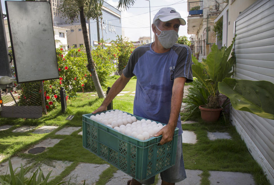 Miguel Sánchez, dueño de una cafetería, descarga su compra de huevos adquirida en el mercado mayorista Mercabal al llegar a su casa el viernes 31 de julio de 2020, en La Habana, Cuba. El gobierno está permitiendo que las empresas privadas compren al por mayor por primera vez. (AP Foto/Ismael Francisco)