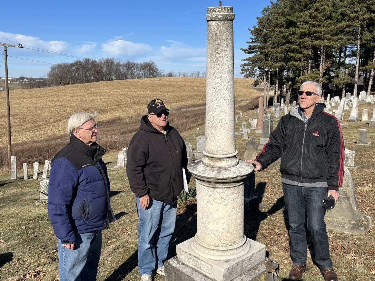JR Bitikofer, left, and Jeff Schrock, members of American Legion Post No. 494, along with Wayne Miller of the Amish & Mennonite Heritage Center in Berlin, examine the tombstone of Dr. Noah W. Yoder, a Civil War veteran who is buried in the Shanesville First Reformed Cemetery in Sugarcreek.