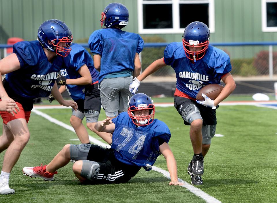 Carlinville High School's Jake Campbell runs the ball during a drill at practice Friday, August 11, 2023.