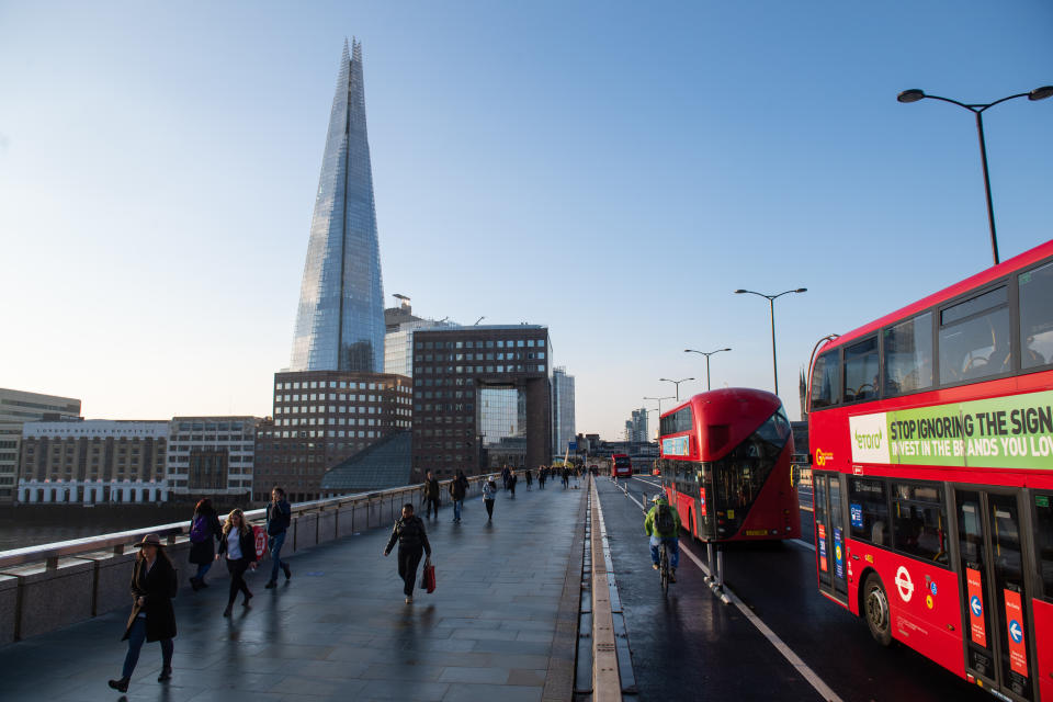 Commuters cross London Bridge, in central London, during morning rush hour after Prime Minister Boris Johnson set out a new three-tier system of alert levels for England following rising coronavirus cases and hospital admissions.