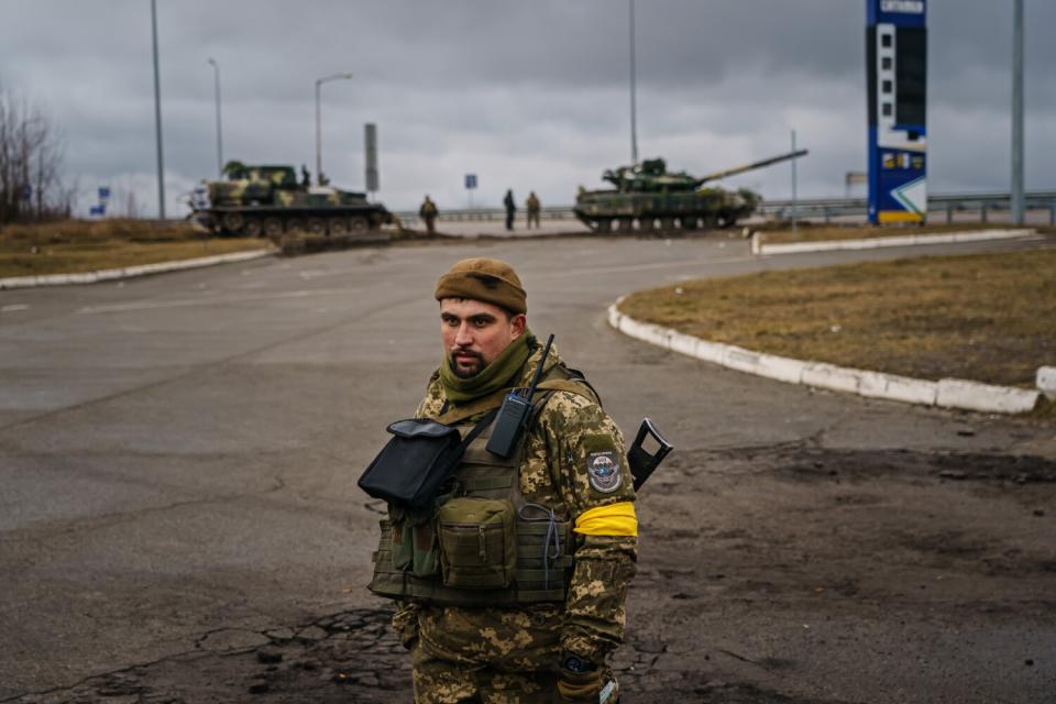 A soldier wears a yellow armband.