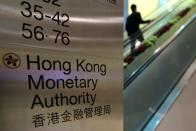 FILE PHOTO: A security guard walks past a directory board of Hong Kong Monetary Authority (HKMA) in Hong Kong
