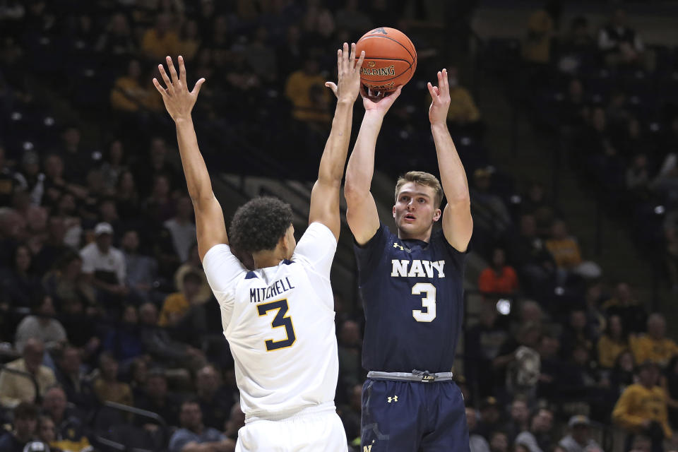 Navy guard Sean Yoder shoots against West Virginia forward Tre Mitchell during the first half of an NCAA college basketball game in Morgantown, W.Va., Wednesday, Dec. 7, 2022. (AP Photo/Kathleen Batten)