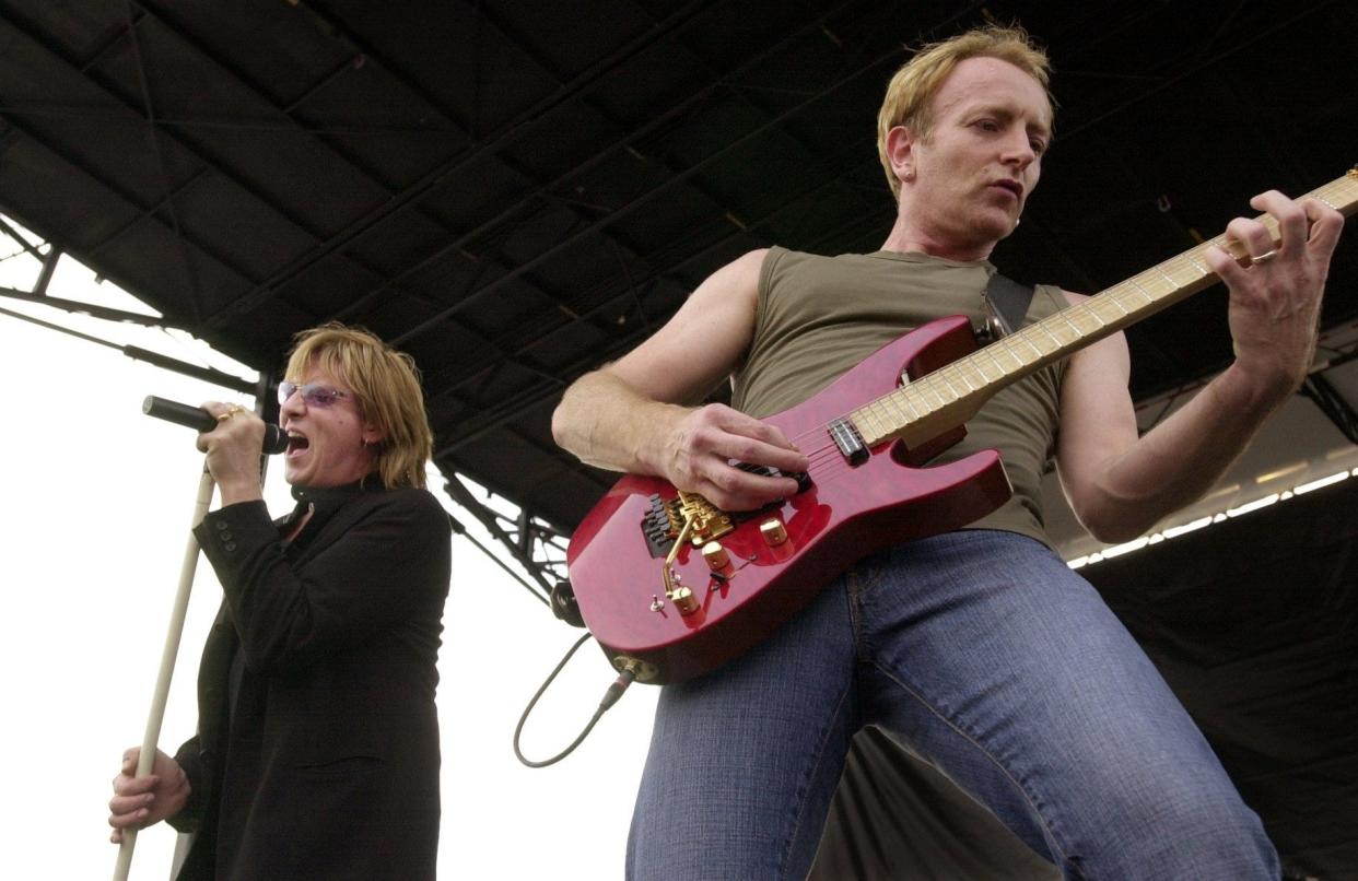 FILE - Lead singer Joe Elliott, left, and guitarist Phil Collen with Def Leppard play during a free concert at the Walmart on Raeford Road Wednesday, July 31, 2002. A Jefferson woman recently was scammed for $11,000 by someone pretending to be Elliott.