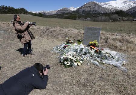 Photographers take pictures at the memorial for the victims of the air disaster in the village of Le Vernet, near the crash site of the Airbus A320 in French Alps March 27, 2015. REUTERS/Robert Pratta