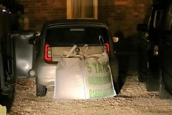 The car, blocked in by gravel.