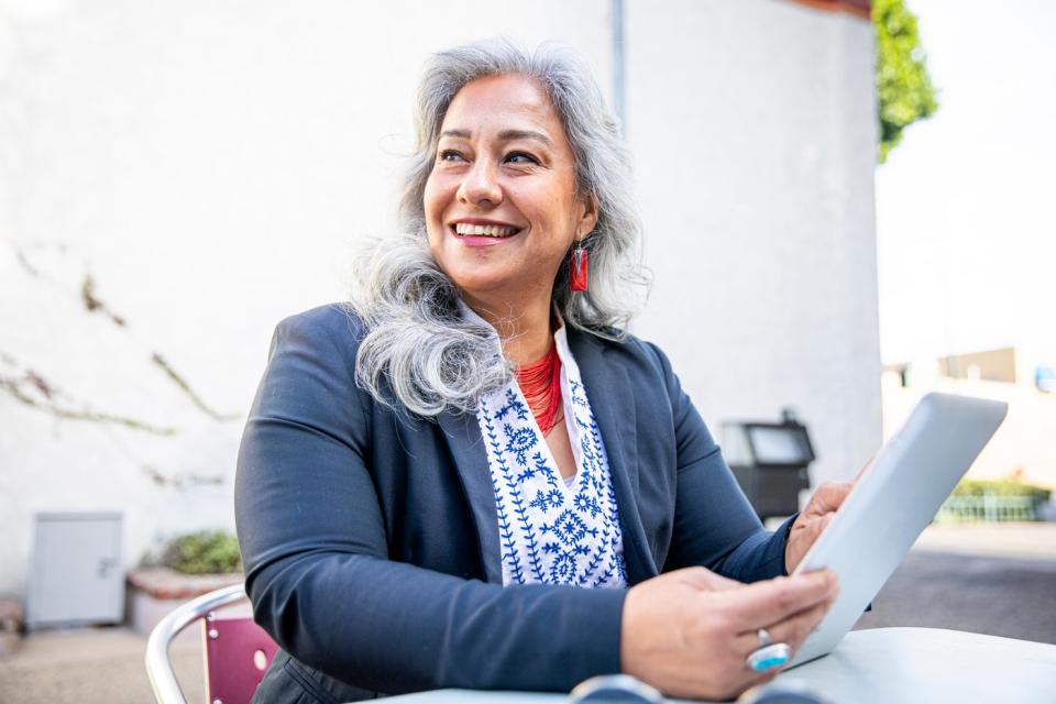 Person smiling and holding a tablet.