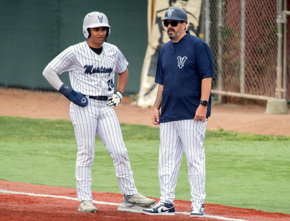 Venture Academy's Xavier Brown talks to assistant coach Jason Monte while on first base during a varsity baseball game at Billy Hebert Field in Stockton on Apr. 25, 2024.