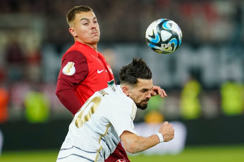 Saarbruecken's Kasim Rabihic (front) and Kaiserslautern's Filip Kaloc battle for the ball during the German DFB Cup semi-final soccer match between 1. FC Saarbruecken and FC Kaiserslautern at the Ludwigspark Stadium. Uwe Anspach/dpa