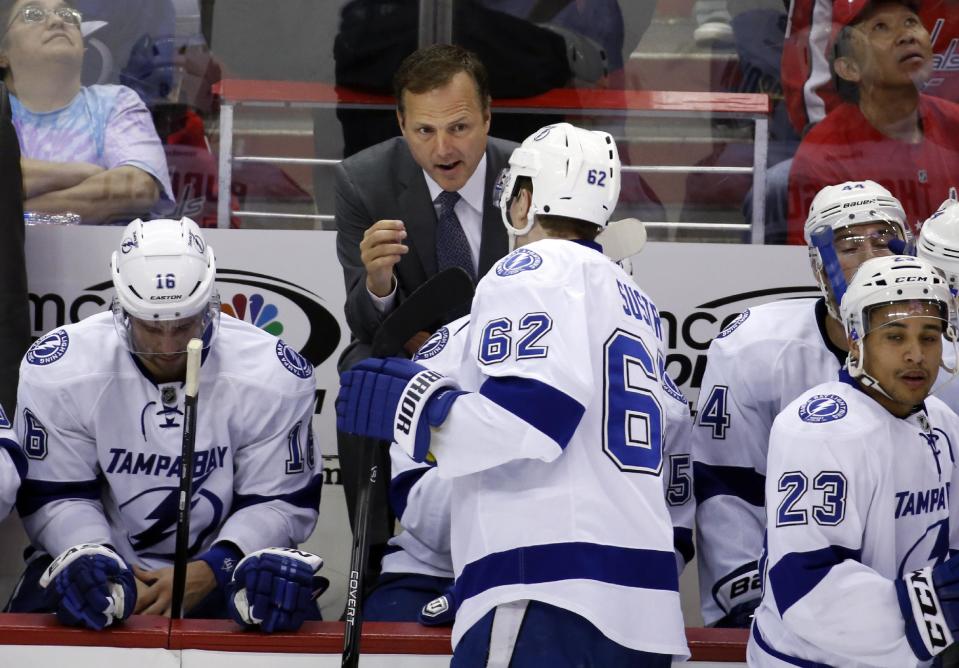 Tampa Bay Lightning head coach Jon Cooper, top, talks with defenseman Andrej Sustr (62), from the Czech Republic, during a timeout in the third period of an NHL hockey game against the Washington Capitals, Sunday, April 13, 2014, in Washington. The Lightning won 1-0 in a shootout. (AP Photo/Alex Brandon)