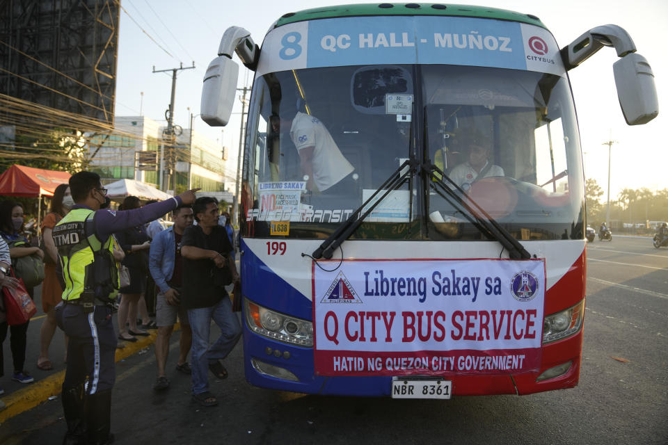 Commuters board a free bus ride during a passenger jeepney strike in Quezon city, Philippines on Monday, March 6, 2023. Philippine transport groups launched a nationwide strike Monday to protest a government program drivers fear would phase out traditional jeepneys, which have become a cultural icon, and other aging public transport vehicles. (AP Photo/Aaron Favila)