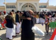 A freed Saudi-led coalition prisoner hugs a relative after his release in a prisoner swap, at Sayoun airport