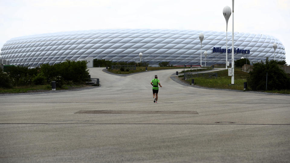 Un hombre trota frente al estadio del Bayern Múnich, el martes 28 de abril de 2020. (AP Foto/Matthias Schrader)