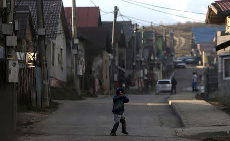 A Roma child walks across a street past refurbished houses near the so called "Sheffield Square" in the town of Bystrany, Slovakia, November 28, 2016. Picture taken November 28, 2016. REUTERS/David W Cerny