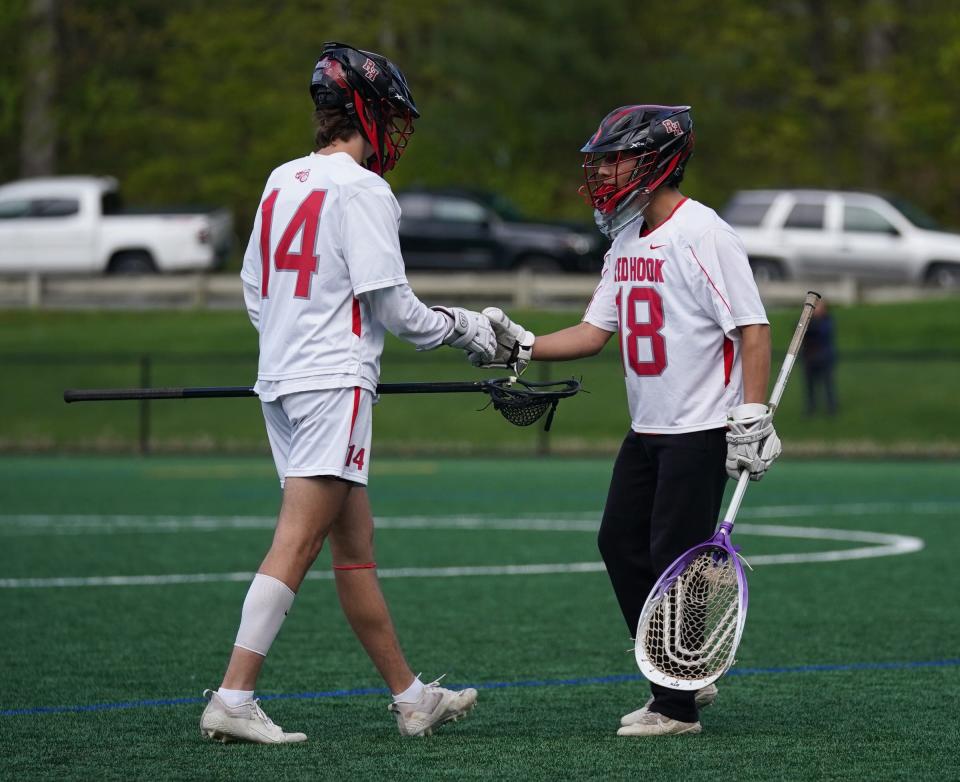 Red Hook's Jackson Taylor (14) and goalkeeper Yoav Alperson (18) bump fists in celebration during their boys lacrosse win over New Paltz on May 3, 2023 at Bard College.