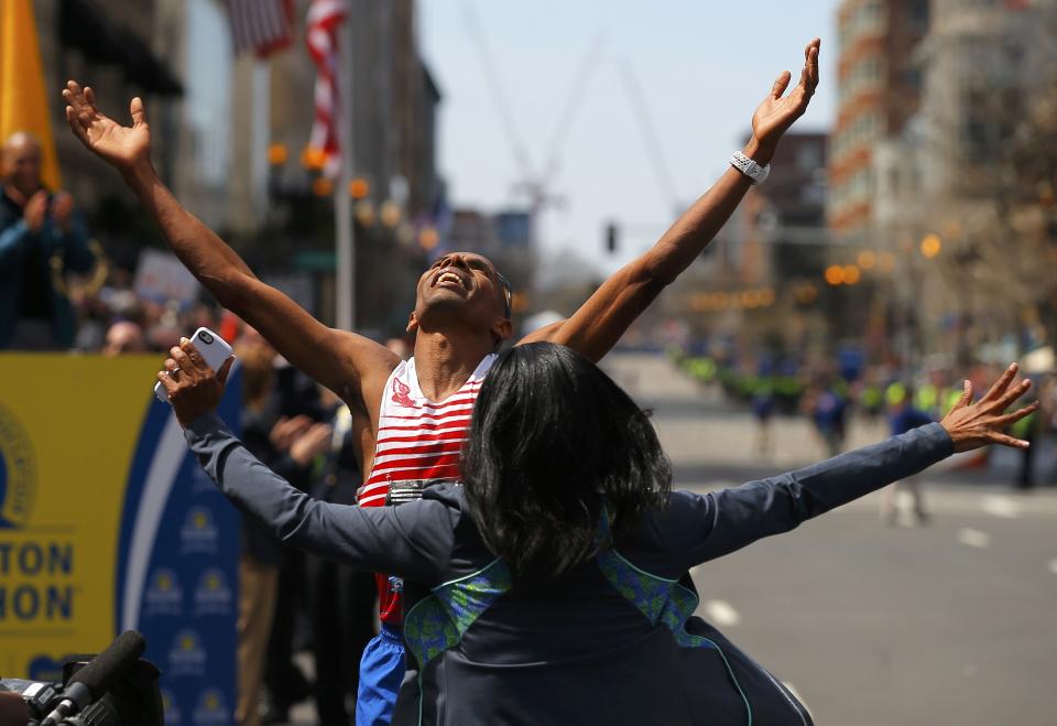 Meb Keflezighi of the U.S. celebrates with his wifre Yordanos Asgedom after winning the men's division at the 118th running of the Boston Marathon in Boston, Massachusetts April 21, 2014. REUTERS/Brian Snyder (UNITED STATES - Tags: SPORT ATHLETICS)