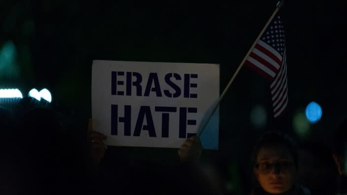 A participant holds a sign and an American flag during a 2018 vigil in front of the White House. A new FBI report says the group most targeted for hate in this country remains Blacks. (Photo by Alex Edelman/Getty Images)