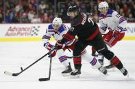 New York Rangers defenseman Brady Skjei (76) and Carolina Hurricanes right wing Nino Niederreiter (21), of the Czech Republic, skate for the puck during the first period of an NHL hockey game in Raleigh, N.C., Friday, Feb. 21, 2020. (AP Photo/Gerry Broome)