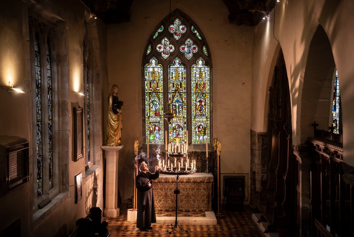 7 February 2023: The Rt Reverend Glyn Webster lights a candle in front of the newly restored Lady Chapel East Window at All Saints North Street in York, one of  thirteen  stained glass windows from the church undergoing conservation work at Barley Studio (PA)