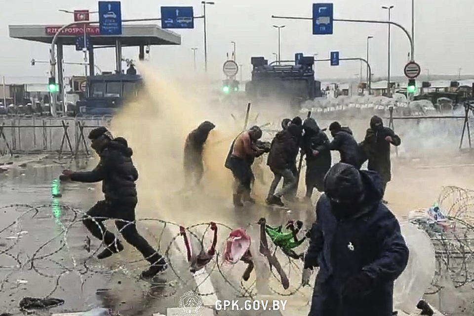 In this handout photo released by State Border Committee of the Republic of Belarus on Tuesday, Nov. 16, 2021, Polish servicemen use a water cannon during clashes between migrants gathering at the checkpoint "Kuznitsa" at the Belarus-Poland border near Grodno, Belarus, on Tuesday, Nov. 16, 2021. Polish border forces say they were attacked with stones by migrants at the border with Belarus and responded with a water cannon. (State Border Committee of the Republic of Belarus via AP)