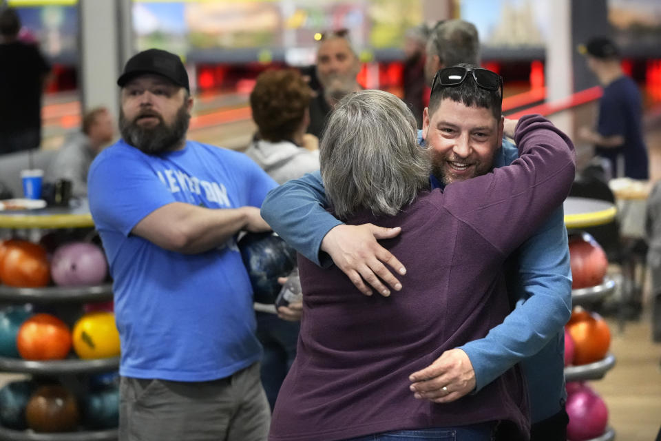 Justin Juray, owner of Just In Time Recreation, hugs a customer during the reopening of the bowling alley six months after a deadly mass shooting, Friday, May 3, 2024, in Lewiston, Maine. (AP Photo/Robert F. Bukaty)