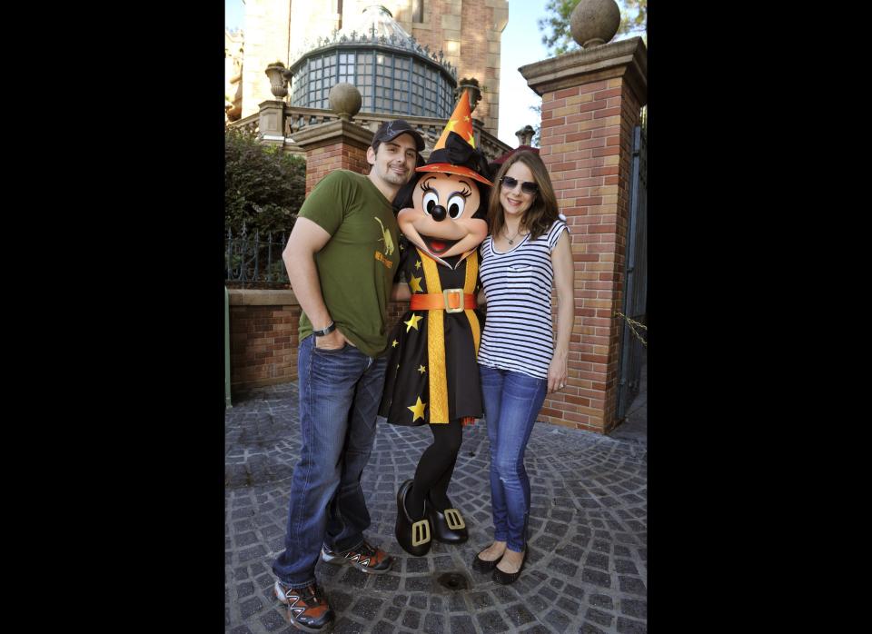 Brad Paisley (left) and his wife, actress Kimberly Williams-Paisley, pose with a Halloween-clad Minnie Mouse in front of the Haunted Mansion at the Magic Kingdom on October 25, 2010 in Lake Buena Vista, Florida, where they were celebrating his birthday.      (Photo by Gene Duncan/Disney via Getty Images)