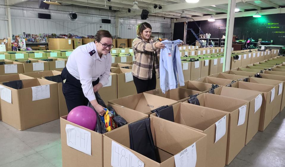 Volunteers, Cadet Aleah Rawls, left, and Brookelyn Walters, right, pack gifts and toys for the Salvation Army’s Angels at its warehouse