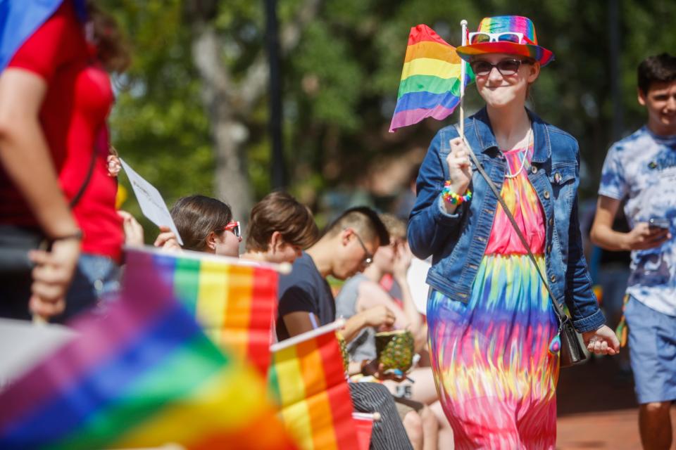 Pride Day participants hold rainbow flags in Gainesville's Bo Diddley Plaza in 2019.