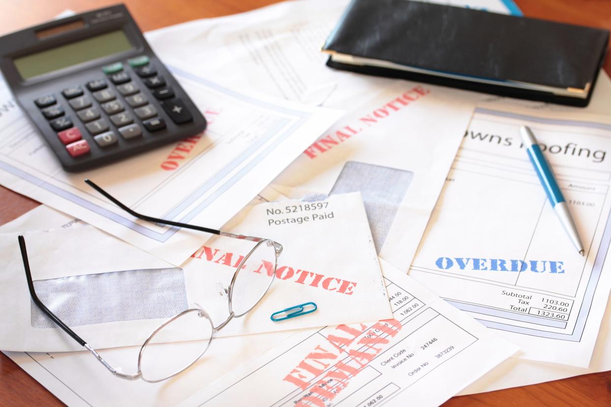 unpaid bills on table with calculator