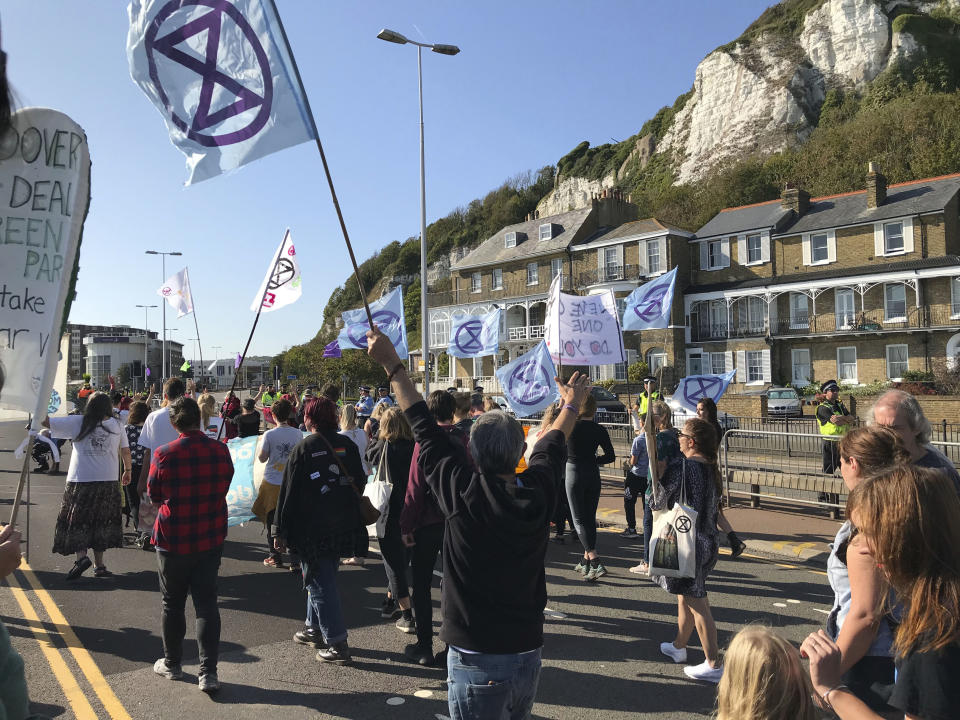 Extinction Rebellion protesters occupy one side of a dual carriageway at the port of Dover, England, Saturday Sept. 21, 2019. Traffic around the Port of Dover, England's major sea connection with France, has been disrupted as a result of a protest by environmental activists. Activists from Extinction Rebellion said their protest around the port is intended to "highlight the vulnerability of the U.K.'s food supply in the face of the ecological and climate emergency." (Michael Drummond/PA via AP)