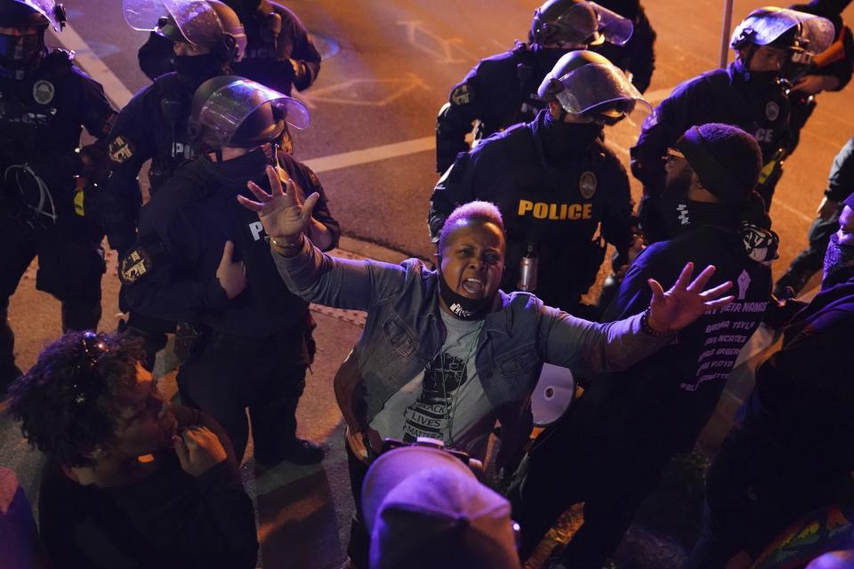 A woman speaks to police as protesters stay on church property, Thursday, Sept. 24, 2020, in Louisville, Ky. Authorities pleaded for calm while activists vowed to fight on Thursday in Kentucky's largest city, where a gunman wounded two police officers during anguished protests following the decision not to charge officers for killing Breonna Taylor. (AP Photo/John Minchillo)