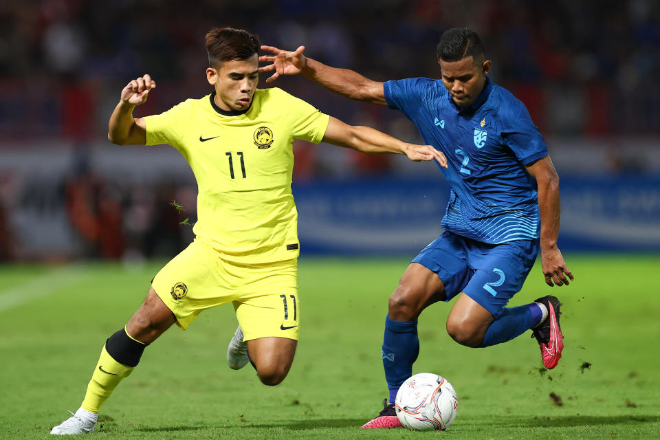 Malaysia's Safawi Rasid (left) tussles for the ball with Thailand's Sasalak Haiprakhon during their AFF Mitsubishi Electric Cup semi-final second leg clash. 