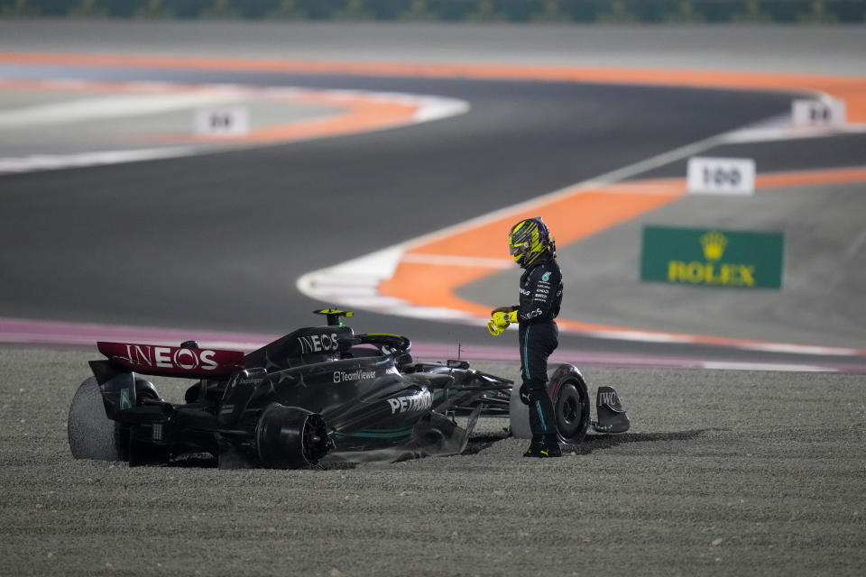 Mercedes driver Lewis Hamilton of Britain stands next to his car after a crash at the start of the Qatar Formula One Grand Prix auto race at the Lusail International Circuit, in Lusail, Qatar, Sunday, Oct. 8, 2023. (AP Photo/Darko Bandic)