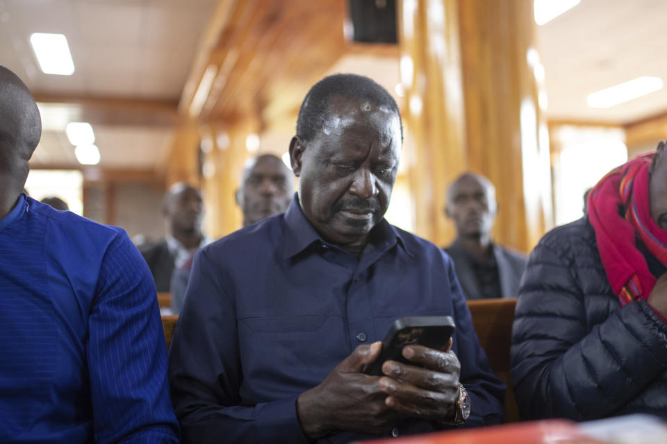Presidential candidate Raila Odinga checks his phone as he attends Sunday mass in St. Francis church in Nairobi, Kenya, Sunday, Aug. 14, 2022. The race remains close between Odinga and Deputy President William Ruto as the electoral commission physically verifies more than 46,000 results forms electronically transmitted from around the country. (AP Photo/Mosa'ab Elshamy)
