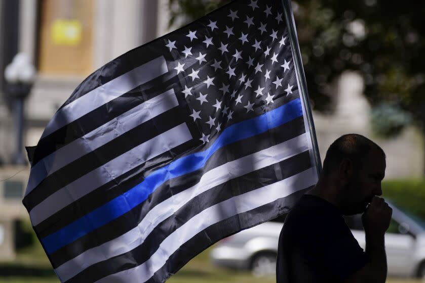 FILE - In this Aug. 30, 2020 file photo, an unidentified man participates in a Blue Lives Matter rally in Kenosha, Wis. University of Wisconsin-Madison's police chief has banned officers from using "Thin Blue Line" imagery while on duty. The move by Chief Kristen Roman follows criticism on social media of a "Thin Blue Line" flag displayed at the police department's office. (AP Photo/Morry Gash, File)