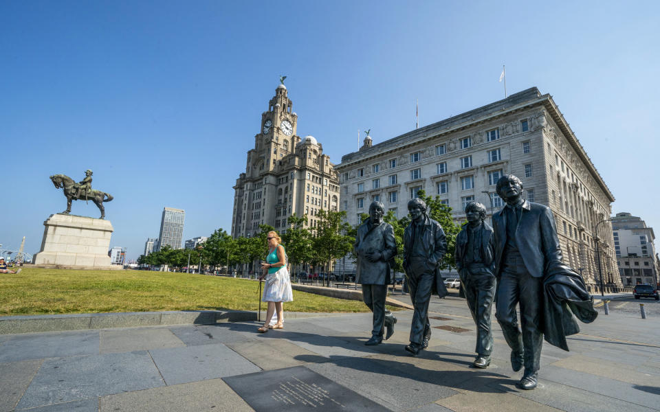 The Beatles statues and Royal Liver Building, centre, on the waterfront area of Liverpool, which has been removed from the World Heritage List Wednesday July 21, 2021. The UN World Heritage committee found developments including the new Everton soccer stadium threatened the value of the city's waterfront. (Peter Byrne/PA via AP)