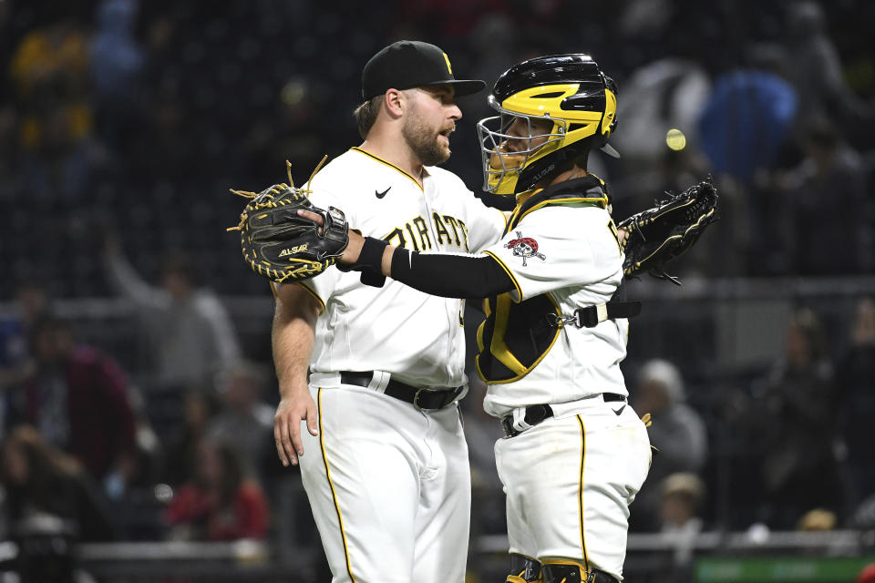 Pittsburgh Pirates pitcher David Bednar, left, and catcher Michael Perez celebrate a win over the Cincinnati Reds in a baseball game in Pittsburgh, Friday, Oct. 1, 2021. (AP Photo/Philip G. Pavely)