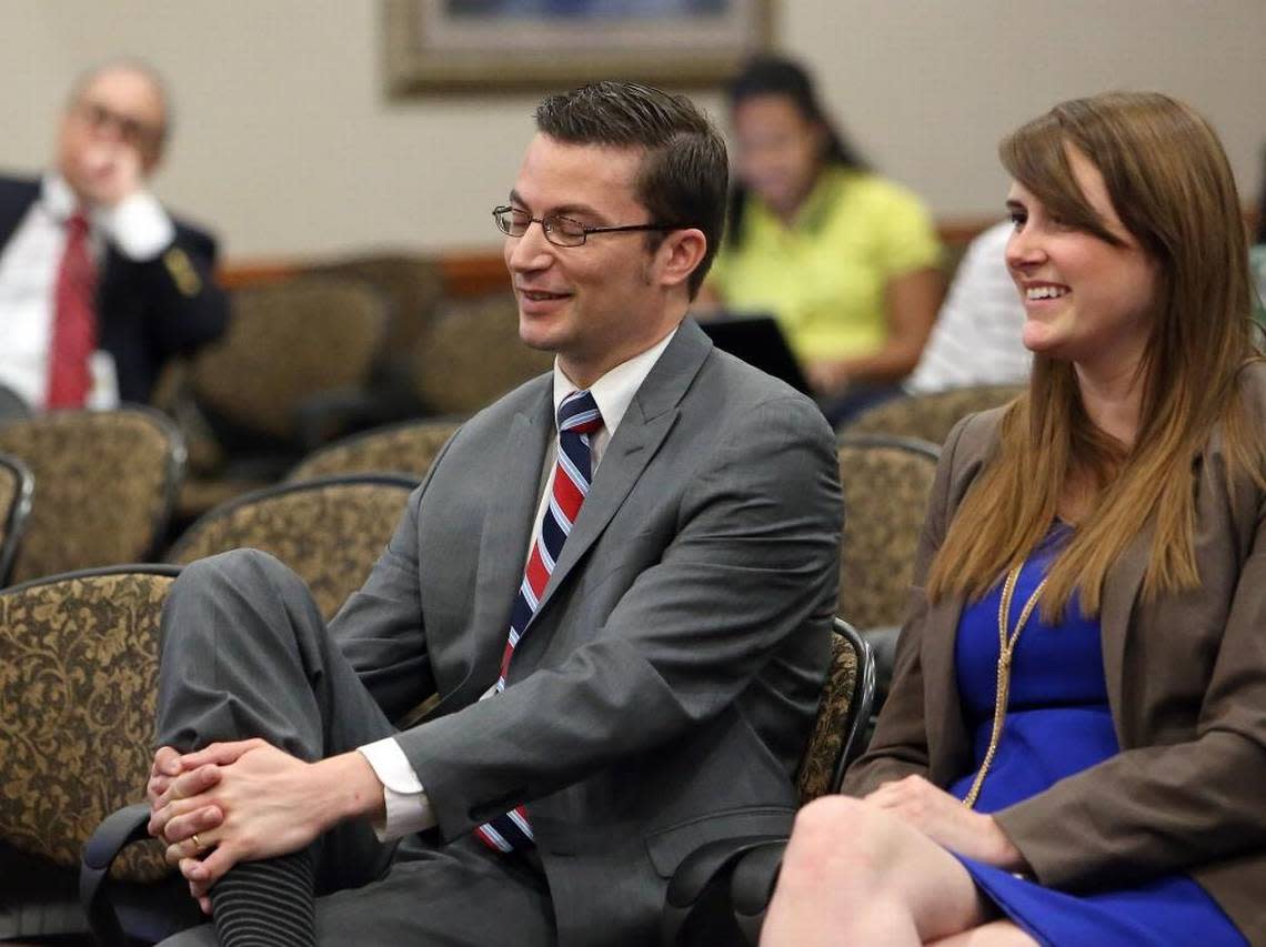 David Altmaier, left, and staffer Caitlin Murray react as Altmaier is confirmed by the Cabinet to be the next insurance commissioner during a meeting, Friday, April 29, in Tallahassee.