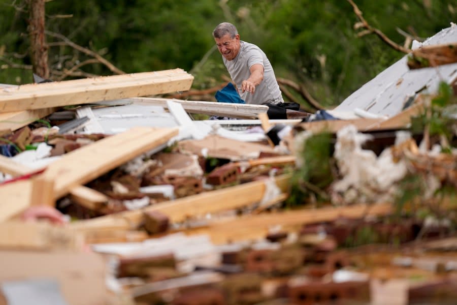 John Bernhart picks up debris at his storm damaged home Thursday, May 9, 2024, in Spring Hill, Tenn. A wave of dangerous storms began crashing over parts of the South on Thursday, a day after severe weather with damaging tornadoes killed several people in the region. (AP Photo/George Walker IV)