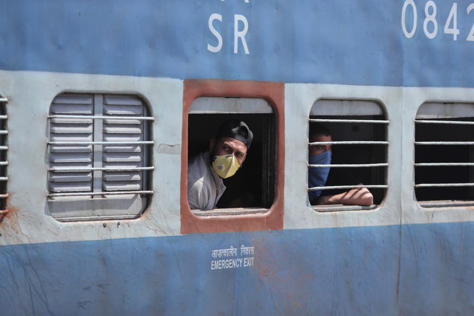 Passengers wearing masks as a precautionary measure against the new virus are seen inside a train in Jammu, India, Monday, March 23, 2020. Authorities have gradually started to shutdown much of the country of 1.3 billion people to contain the outbreak. For most people, the new coronavirus causes only mild or moderate symptoms. For some it can cause more severe illness. (AP Photo/Channi Anand)