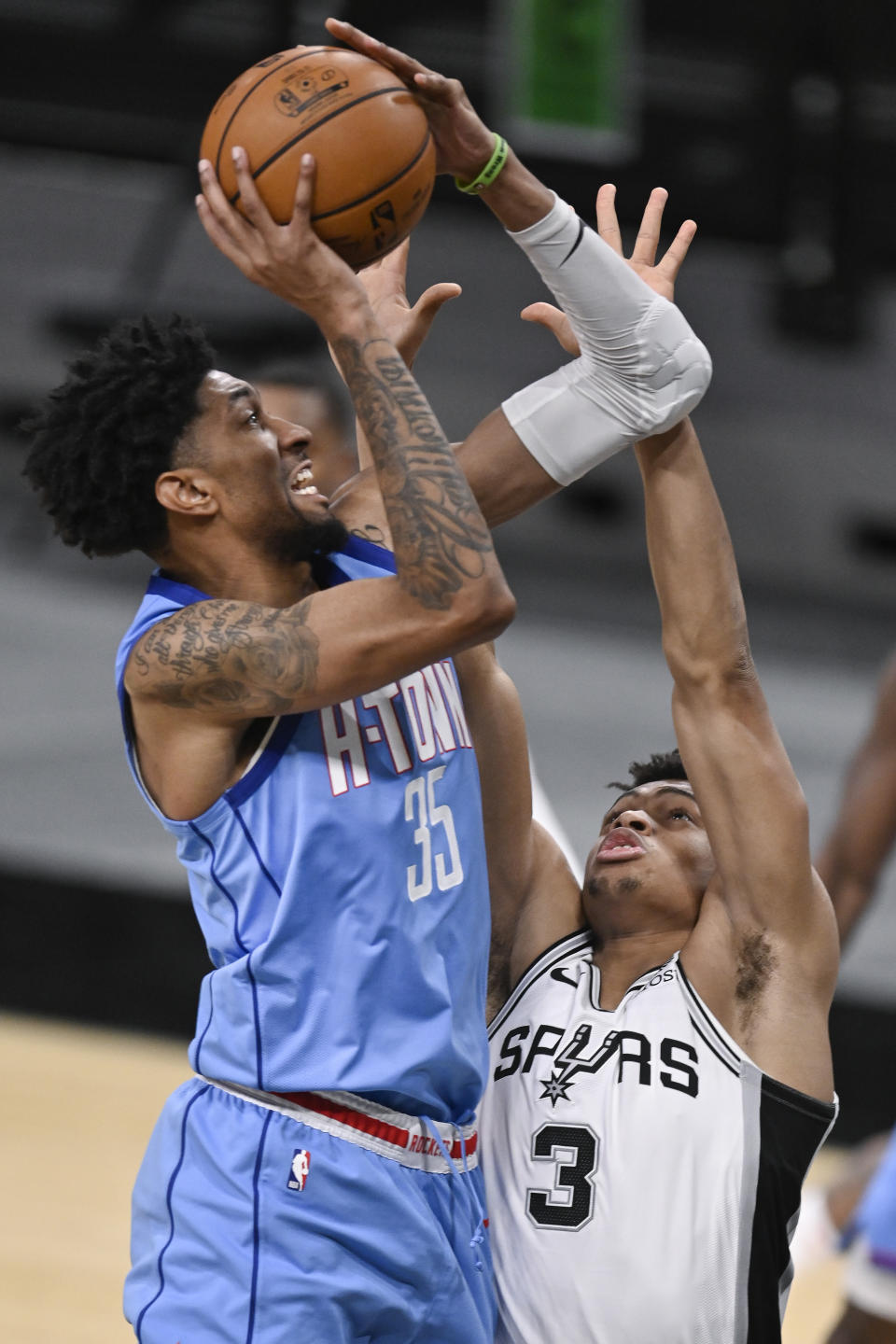 Houston Rockets' Christian Wood (35) attempts to shoot against San Antonio Spurs' Keldon Johnson during the second half of an NBA basketball game, Saturday, Jan. 16, 2021, in San Antonio. (AP Photo/Darren Abate)