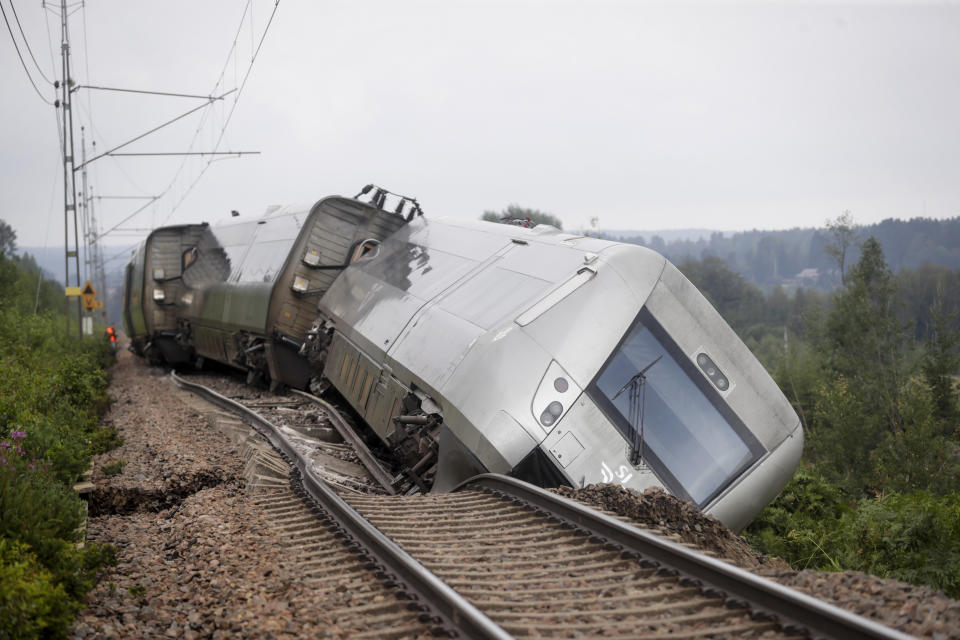 A passenger train carrying 120 passengers is seen derailed between Iggesund and Hudiksvall in Sweden, Monday Aug. 7, 2023. Three people had been taken to hospital in Sweden when two of a train's passenger cars went off the tracks in Hudiksvall, north of Stockholm, police said. The derailment happened because ”the embankment has been undermined by the heavy rain and landslides,“ they said, adding that the extent of their injuries is unclear. (Mats Andersson/TT News Agency via AP)