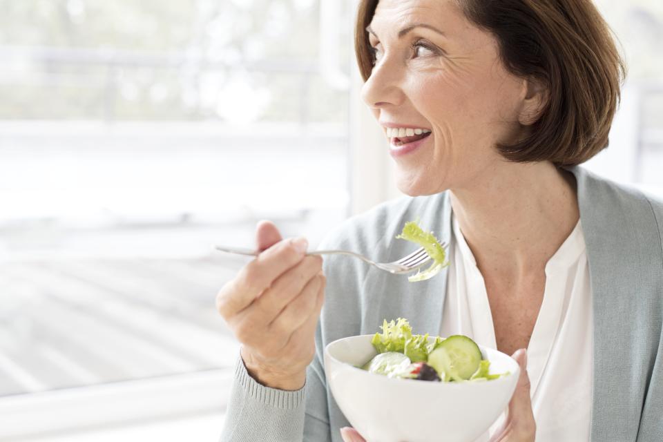 Mature woman eating salad.
