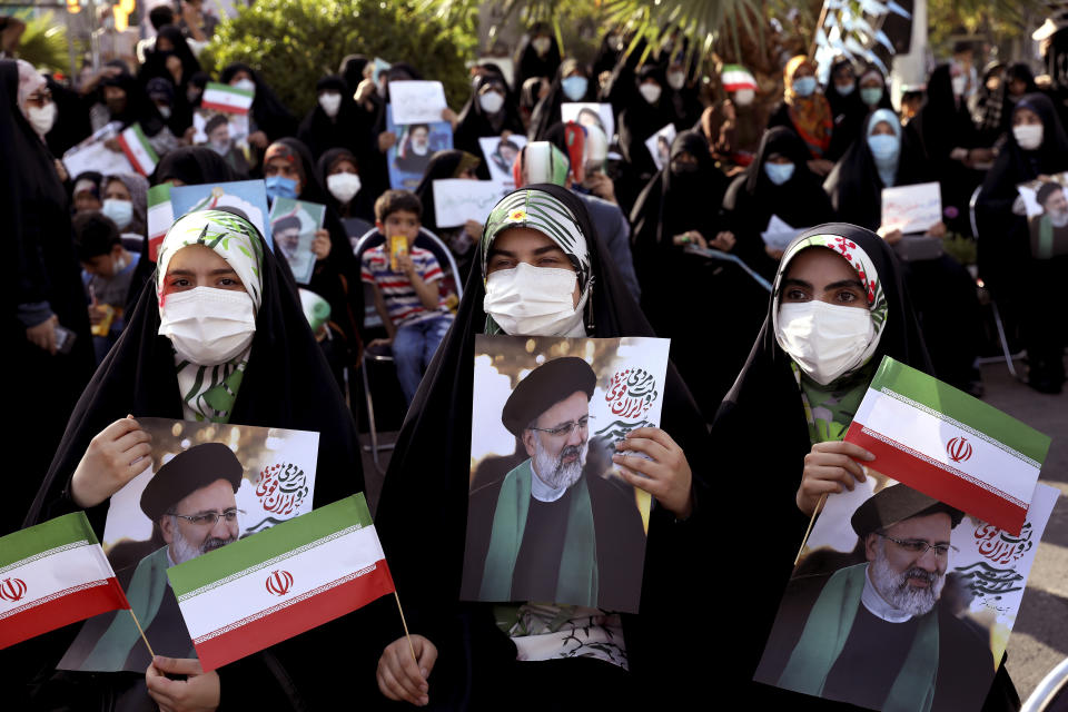 Supporters of presidential candidate Ebrahim Raisi hold signs during a rally in Tehran, Iran, Wednesday, June 16, 2021. Iran's clerical vetting committee has allowed just seven candidates for the Friday, June 18, ballot, nixing prominent reformists and key allies of President Hassan Rouhani. The presumed front-runner has become Ebrahim Raisi, the country's hard-line judiciary chief who is closely aligned with Supreme Leader Ayatollah Ali Khamenei. (AP Photo/Ebrahim Noroozi)